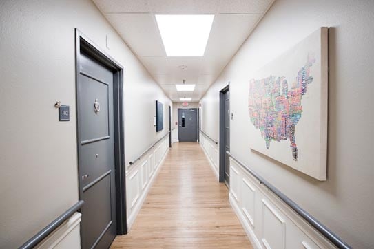 Light wood flooring, grey walls, black doors, and an art piece of the United States